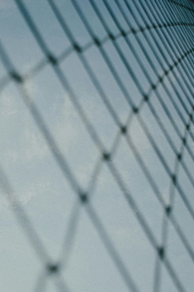 Wire metal sports fence against cloudless sky