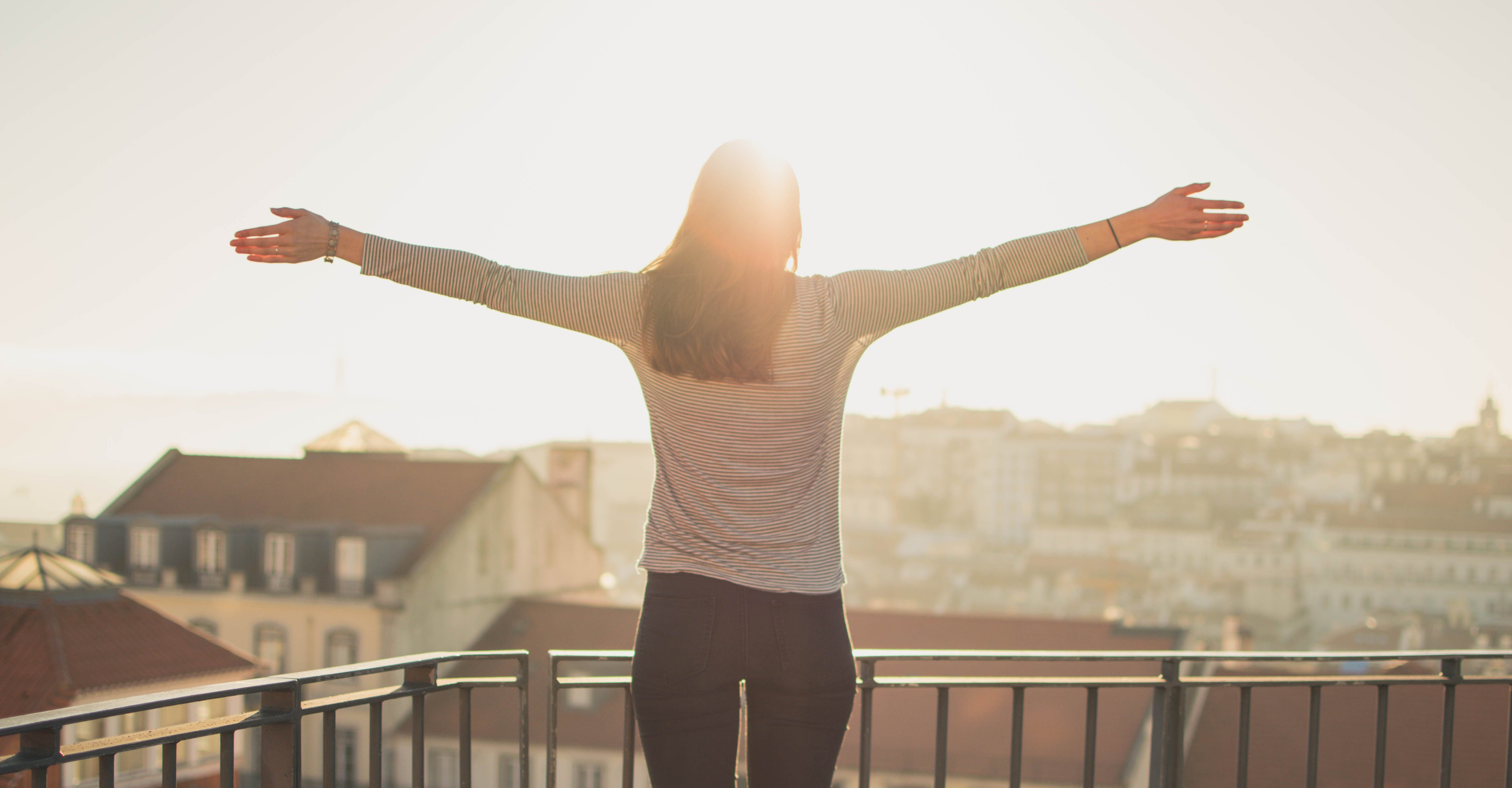 Empowered woman looking at sunrise in power pose