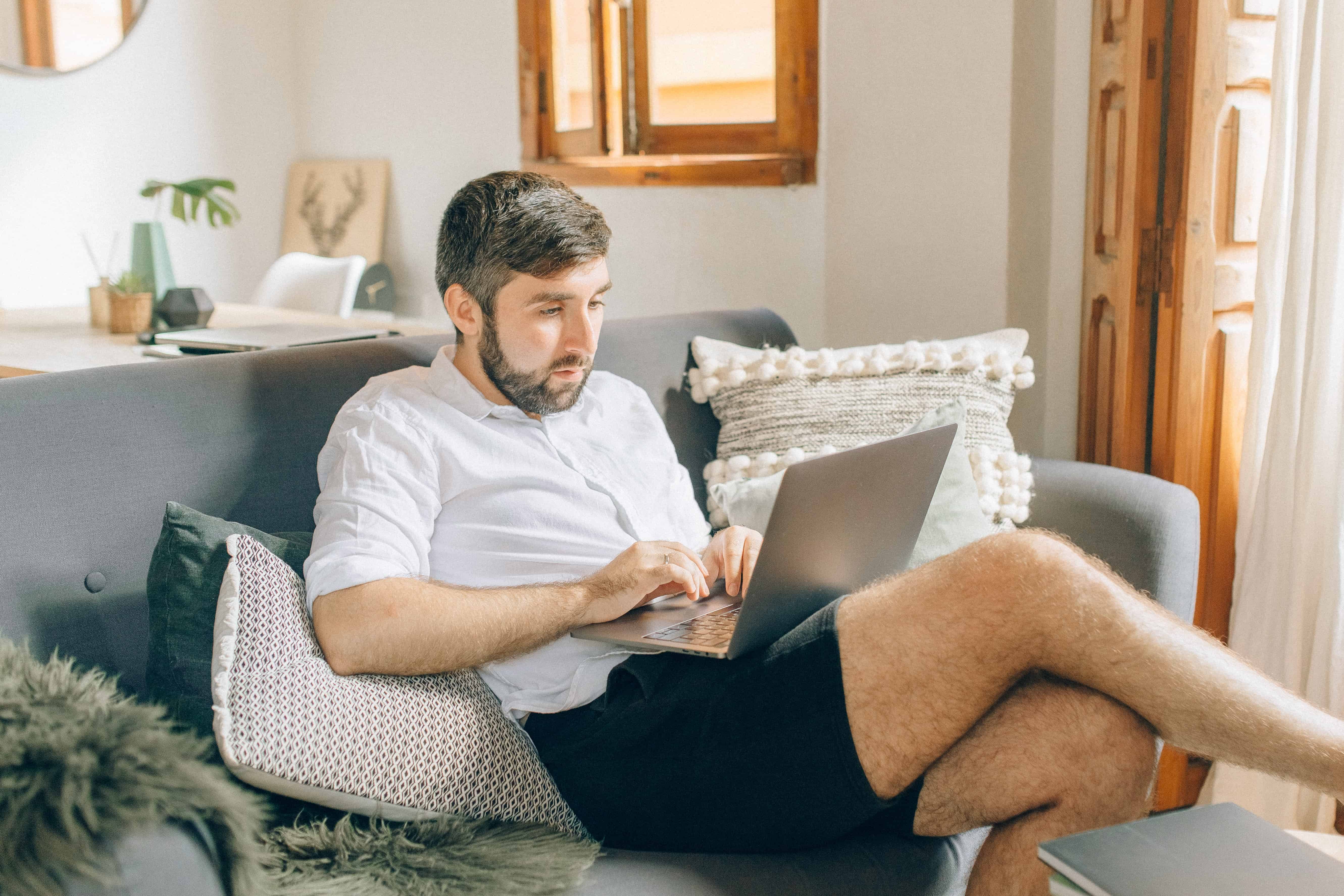 Man working on laptop on home couch